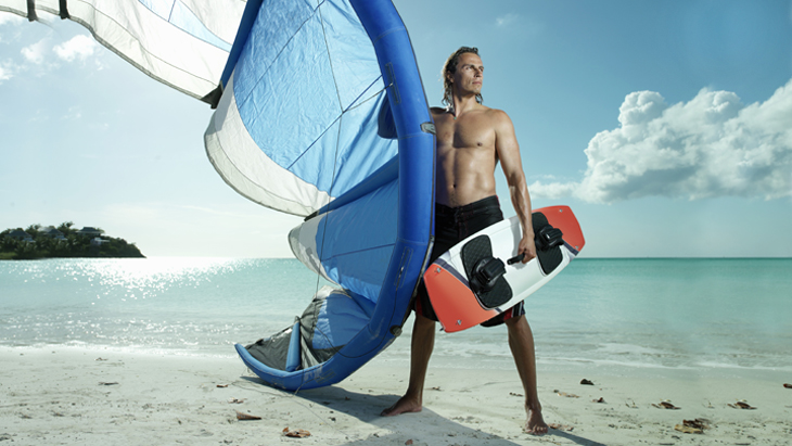 Man with windsurfing gear on beach