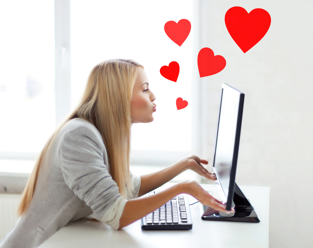 virtual relationships, online dating and social networking concept - woman sending kisses with computer monitor
