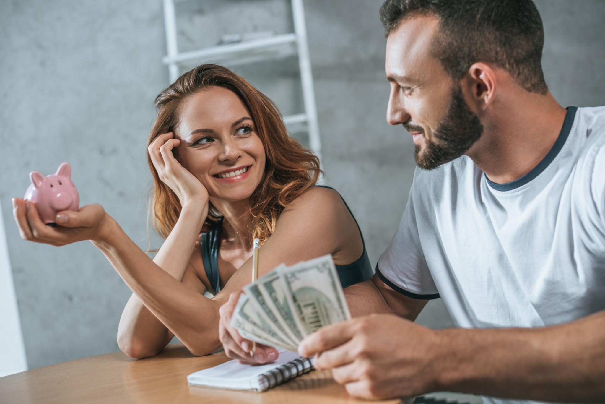 happy couple planning family budget and looking at each other in living room